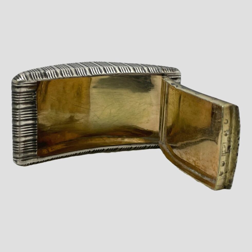 Photo of George III snuff box this time displayed open and on its side to show the full gilt interior which is in a reasonable condition for its age. The lid is open to the right and gilt on inside of lid is also visible.