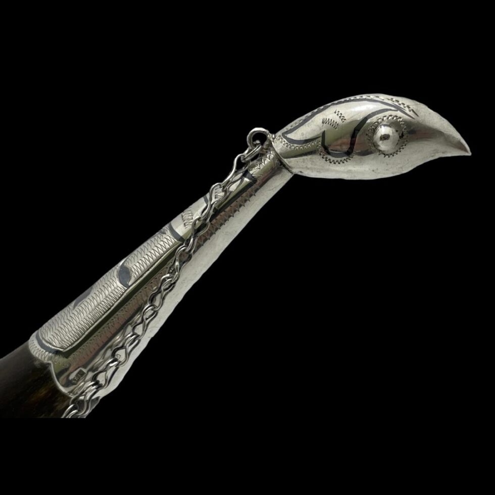 Close up photo of the silver bird head and neck of drinking vessel.