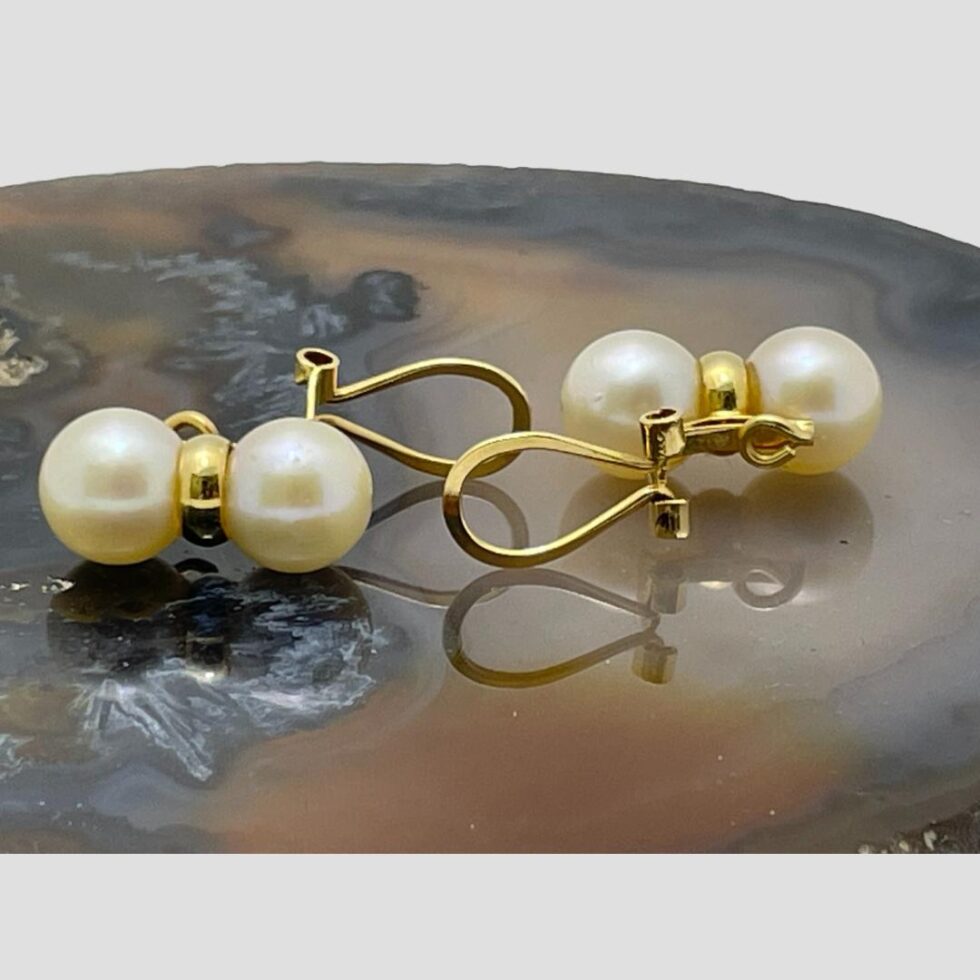 Photo of both earrings still on the agate slice this time they are laid down with clips shown open and posed head to tail. The hallmark on one in foreground is just visible.