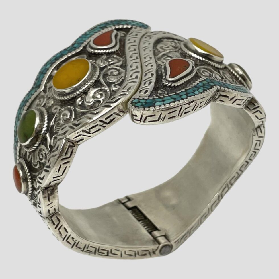 Photo of bracelet again stood upright on its hinge this time displayed with the 2 sides to the left and right corners to show the inside of hinge area.