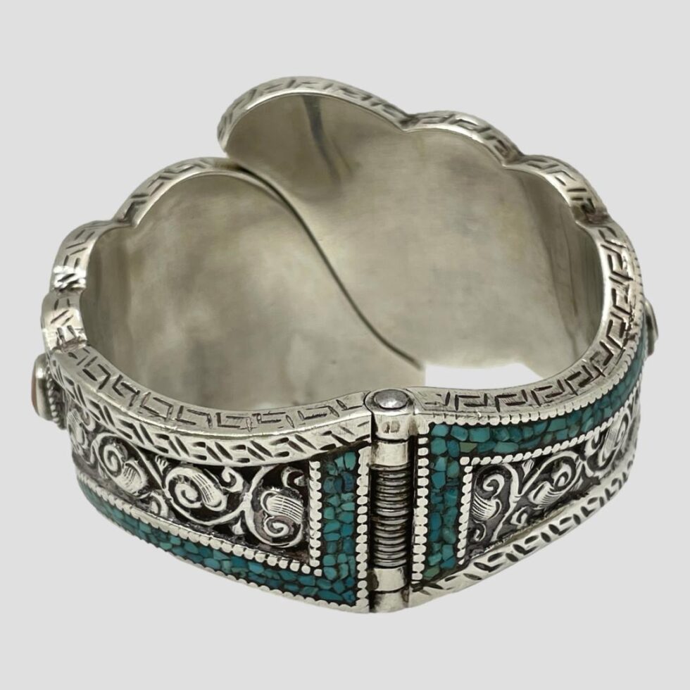 Photo of chunky hinged silver bracelet displayed from the back showing the hinge area in the foreground. The profile head hallmark is just visible at the top of the hinge.