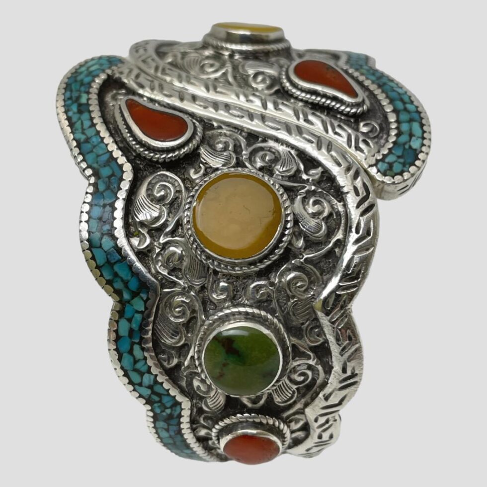 Photo of chunky hinged silver bracelet displayed standing upright on its hinge area with almost one full half of the bracelet on display in close up.