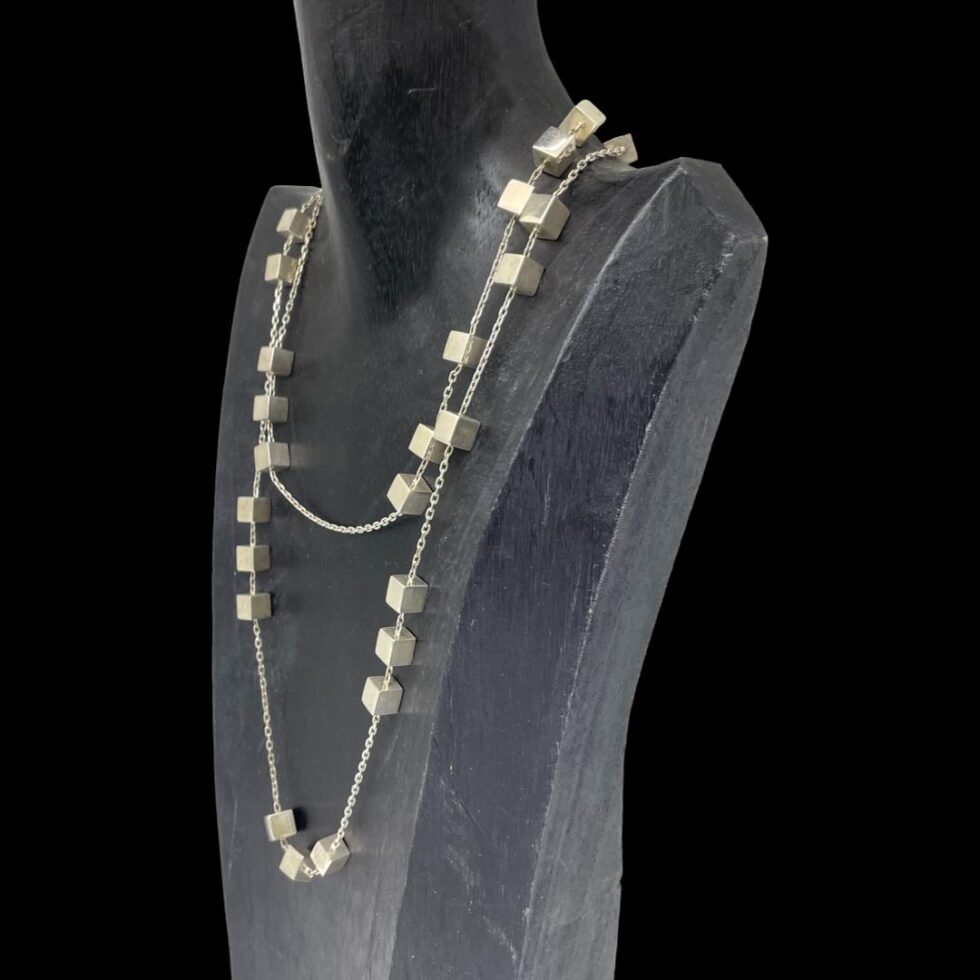 Photo of Georg Jensen Aria necklace still displayed on a black wooden stand and this time with the stand facing towards the left showing a slight side angle for the necklace.