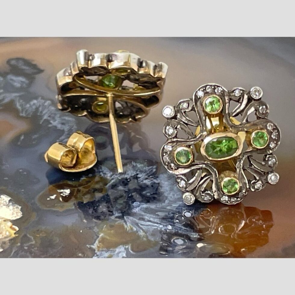 Photo of earrings this time with one on left facing away from camera showing the back and post with butterfly removed. The right one is the front of the earring.