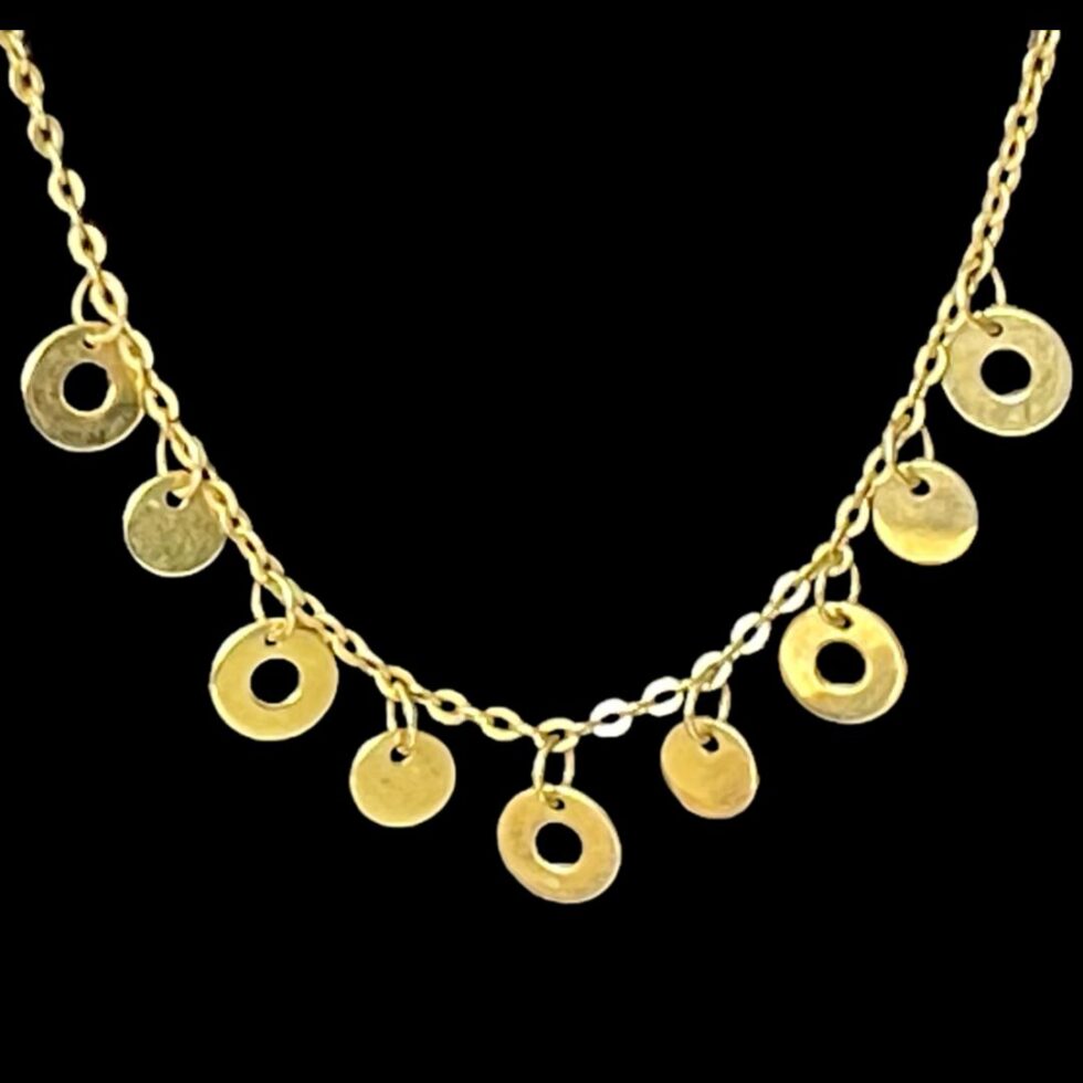 Close up photo of the alternating discs at the front of the necklace. There are 5 ringed discs which are slightly bigger and 4 full discs.