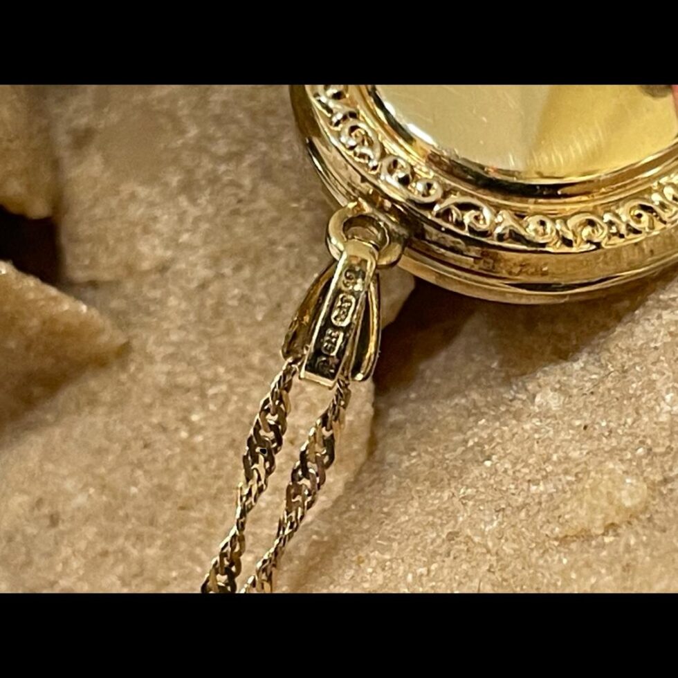 Close up photo of the full hallmark on the cameo locket bail.