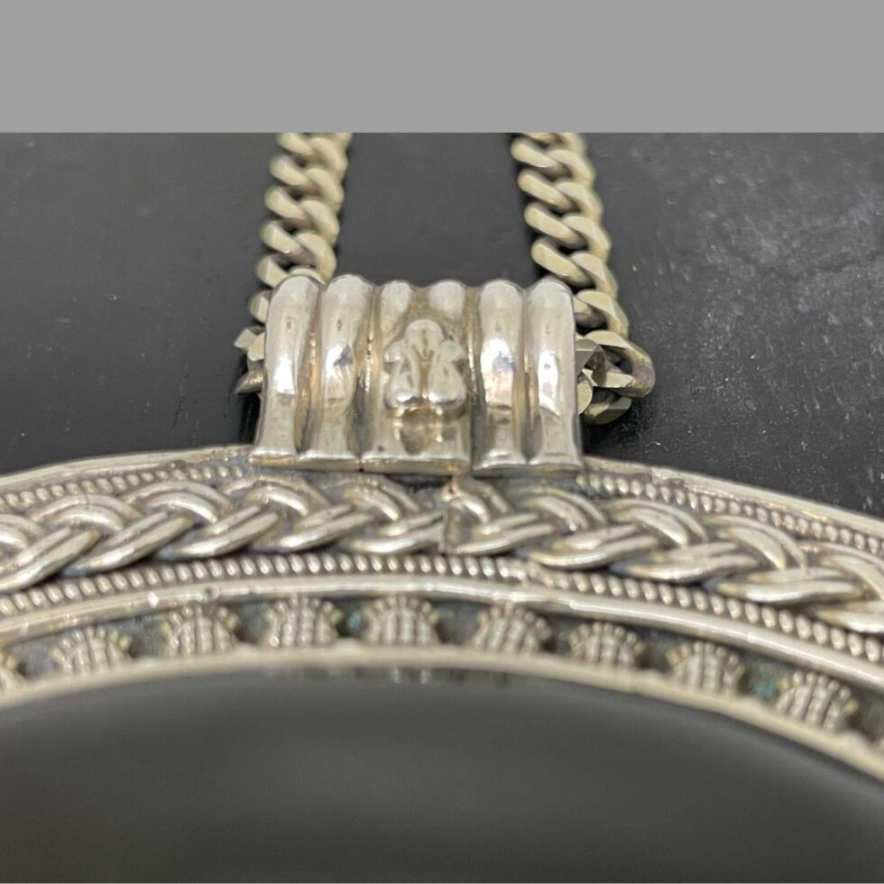 Close up photo of the bee creature on the front of the pendant bail.