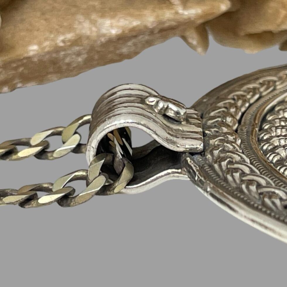 Close up photo of the pendant bail from a side angle. The bail is a generous size and could fit a wider chain of preference.