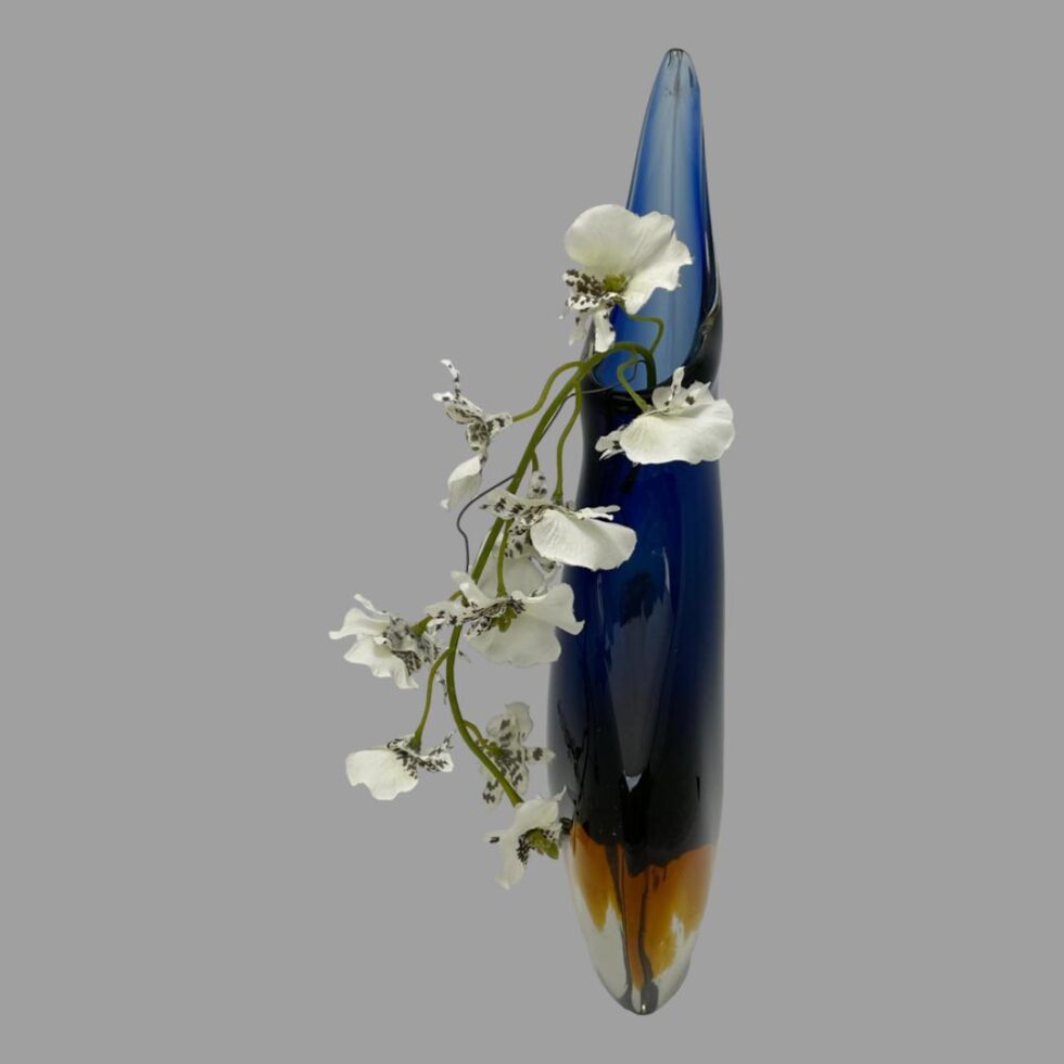 Photo of vase from a side angle - this is the slimmest view of the vase. There is a spray of white orchids cascading down to the left. A vase to fit even the tightest of spaces!