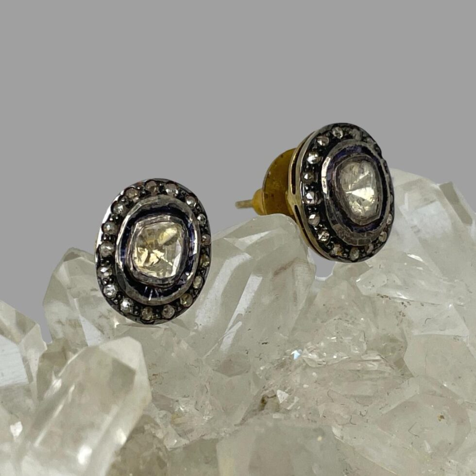 Photo of both stud earrings with left one forward facing and one on right facing to the right bottom corner. The butterfly on this one is just visible.