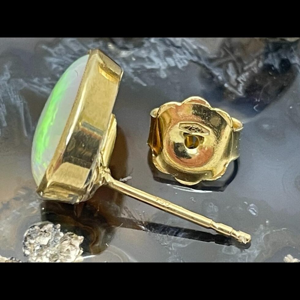 Close up photo of the 750 (18 karat gold) hallmark on one earring post and butterfly.