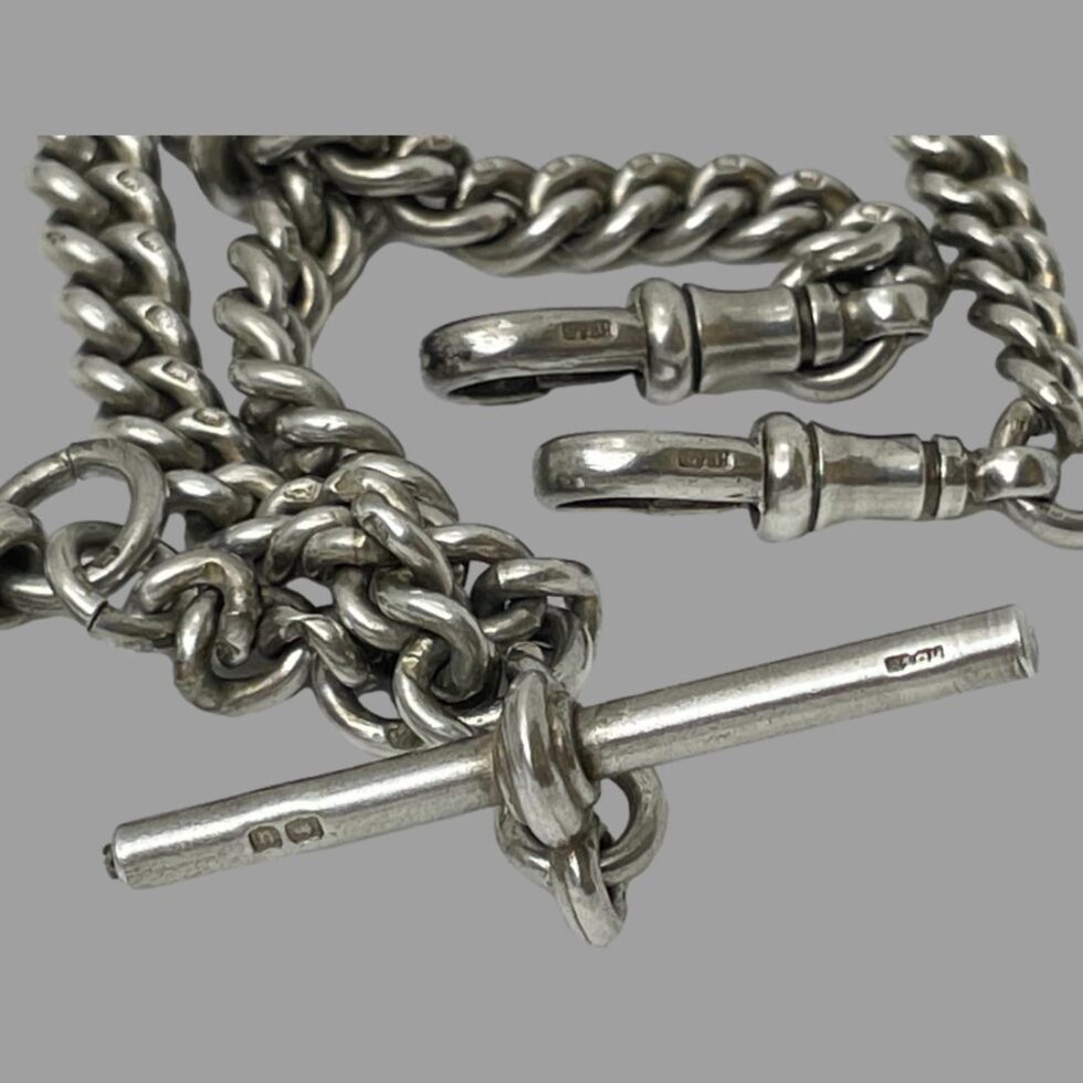 Close up of the hallmark and makers initials on the T-bar and the hallmark on the sides of both dog clips.