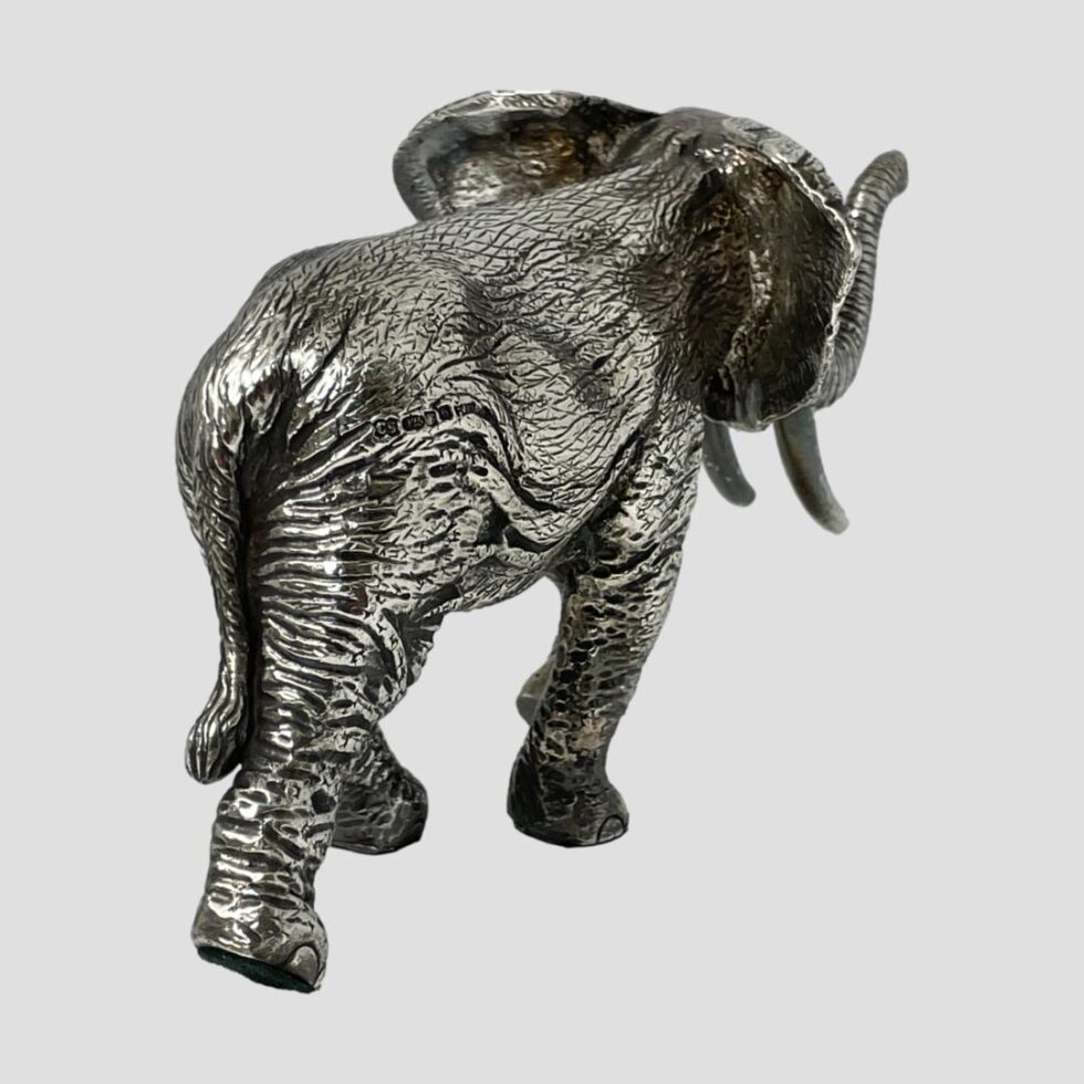 Photo of the silver encased African elephant walking away from the camera now with the rump in the bottom left corner.