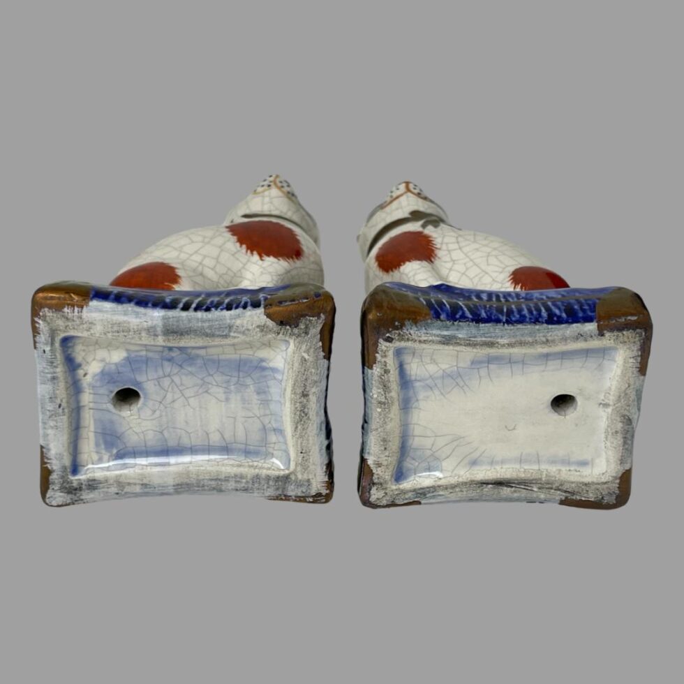 Photo of the base of the 2 Staffordshire cats displayed laid flat to show their bases. The firing hole is visible on both bases