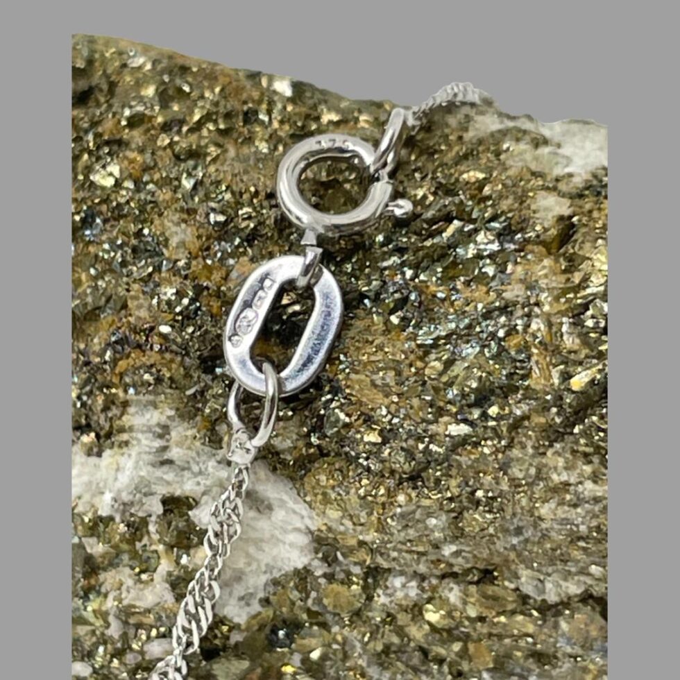 Close up photo of hallmarks on the clasp of the white gold necklace.