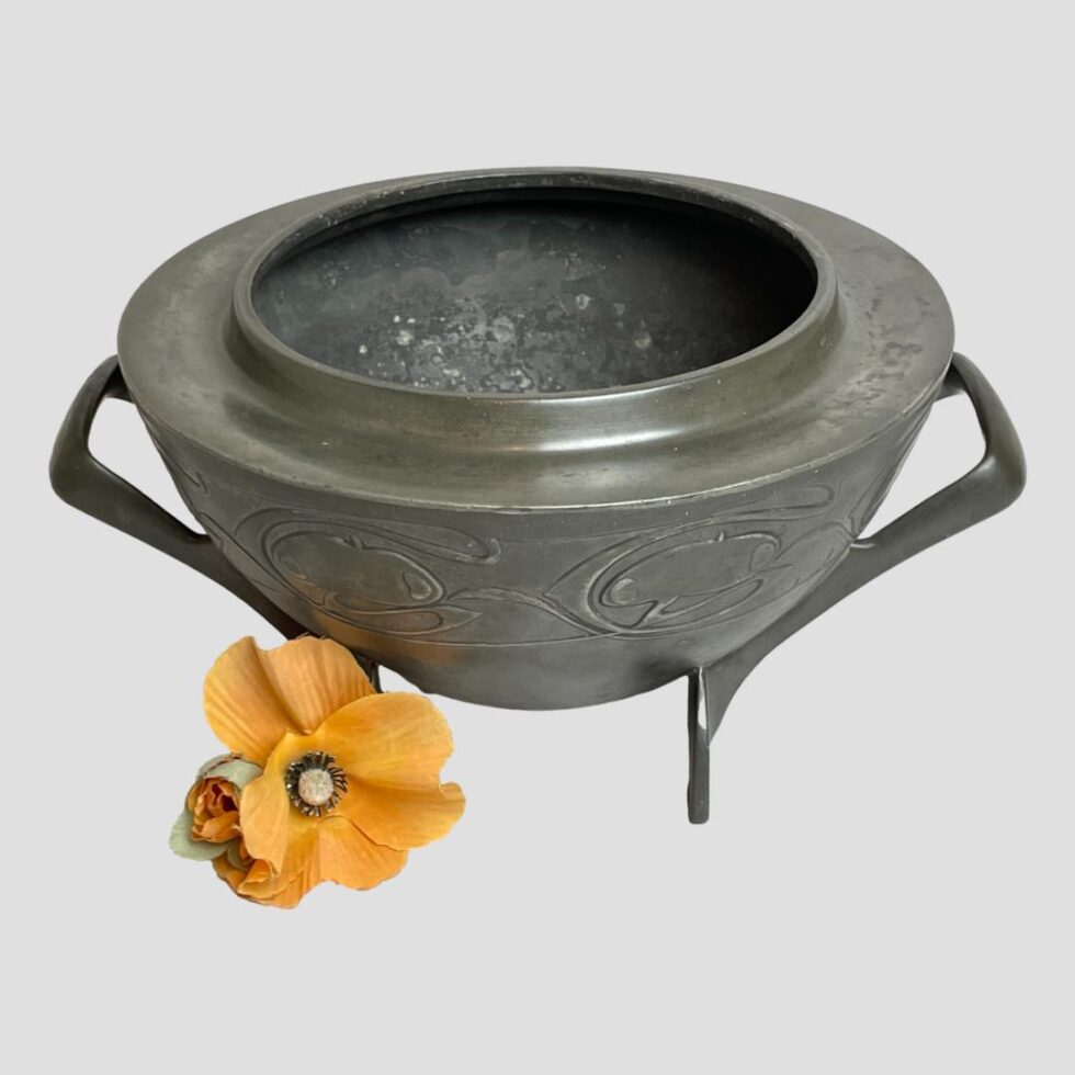 Secondary photo of Knox Turdic pewter bowl this time from a slightly raised angle peering just into the top of the bowl. The little poppy flower is still to the bottom left.