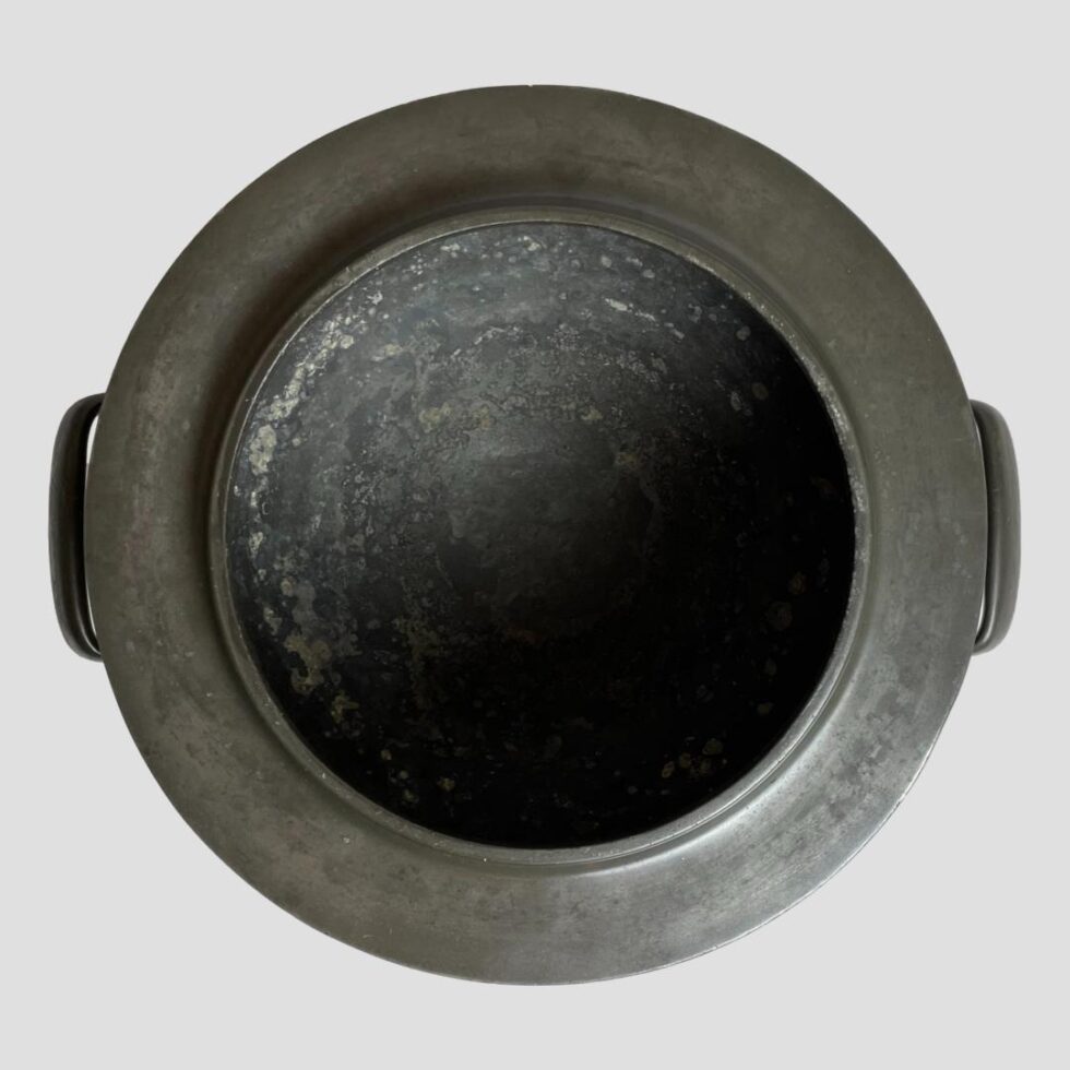 Photo looking straight down into the mouth of the Knox Tudric pewter bowl. The mouth has a one inch frame around the top with a short rim at the actual opening.