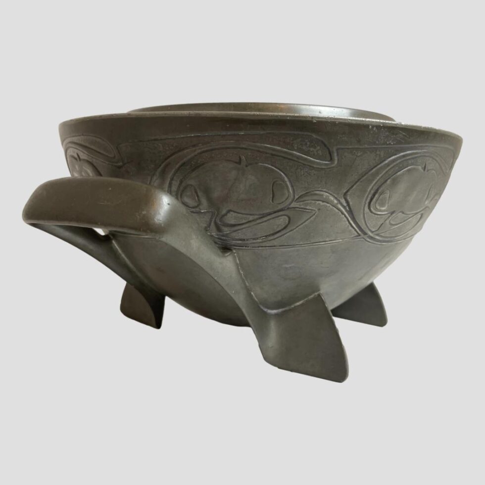Photo of Knox Tudric pewter bowl seen from a lower side angle with one handle in the left foreground.
