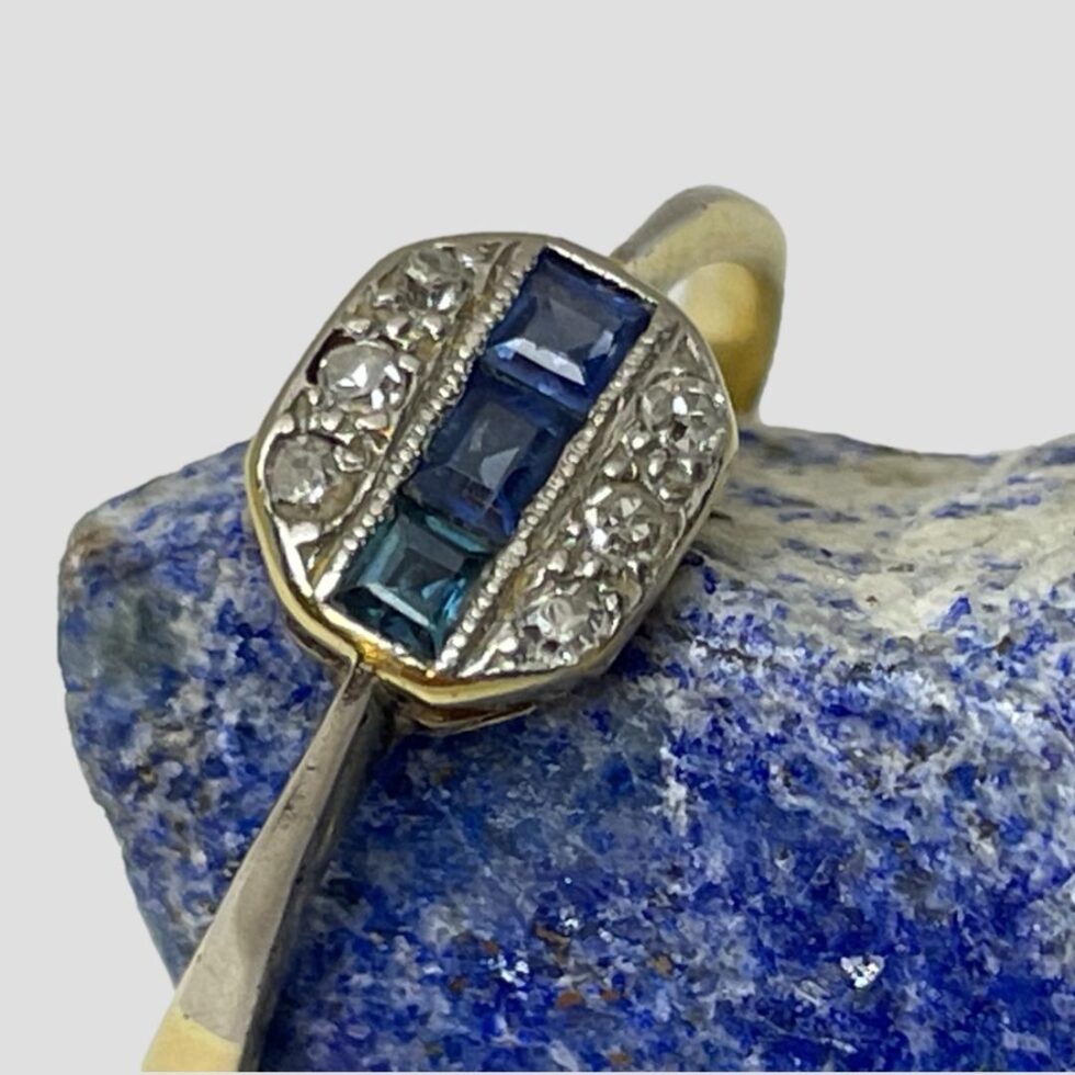 A close up photo of the ring front. The ring is displayed hooked over the edge of the lapis rock and seen diagonally.