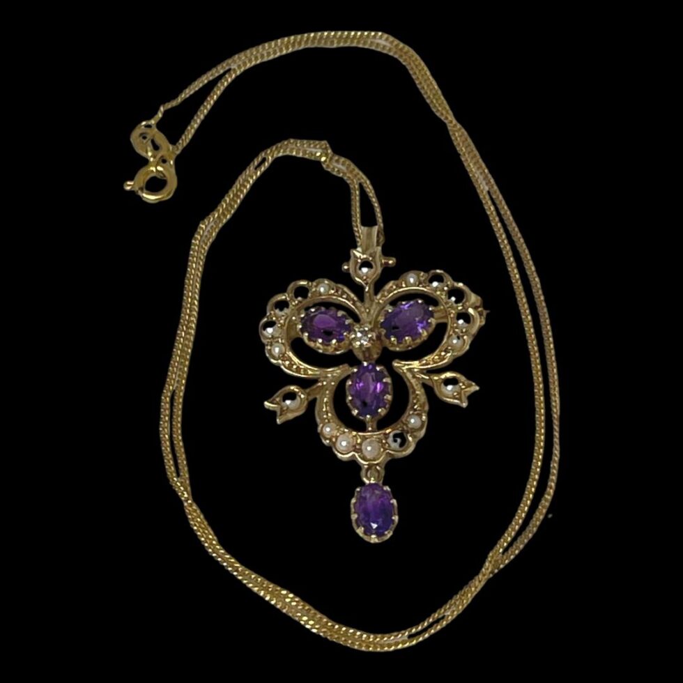 For of entire ensemble displayed on a flat surface with the chain extended up and around the pendant/brooch.