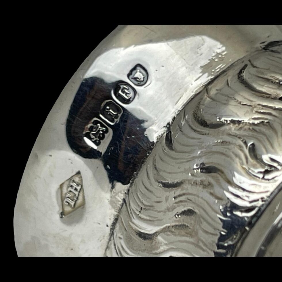 Close up photo of the British import hallmark around the rim of the tricorn hat.