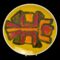 Main photo of Poole yellow Delphis dish displayed on a plate stand and against a black background. The abstract design to the centre in orange red and brown blocks of different shapes put together. To me looks like a person with arms raised in a dancing swirl.