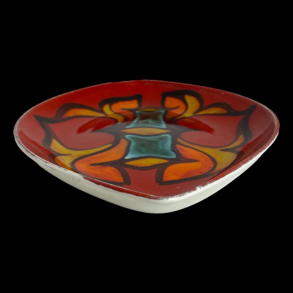 Photo of red Poole Delphis dish laid flat with the longer end of almond shaped dish in the foreground. The photo is taken at a slightly raised angle looking diagonally down.