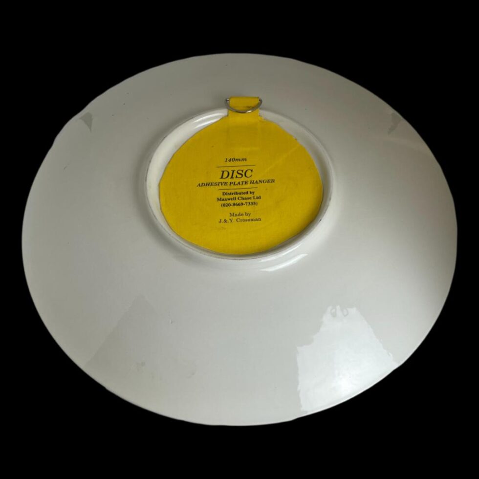 Photo of the back of Poole yellow Delphis dish showing the yellow wall adhesive disc.