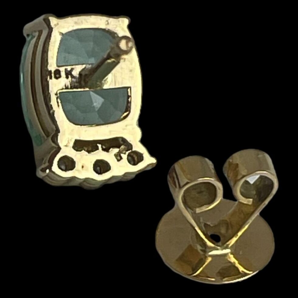 Photo of the back of one earring shown with butterfly removed and placed flat side down in front of the stud. The 18k hallmark is visible on the back of stud.