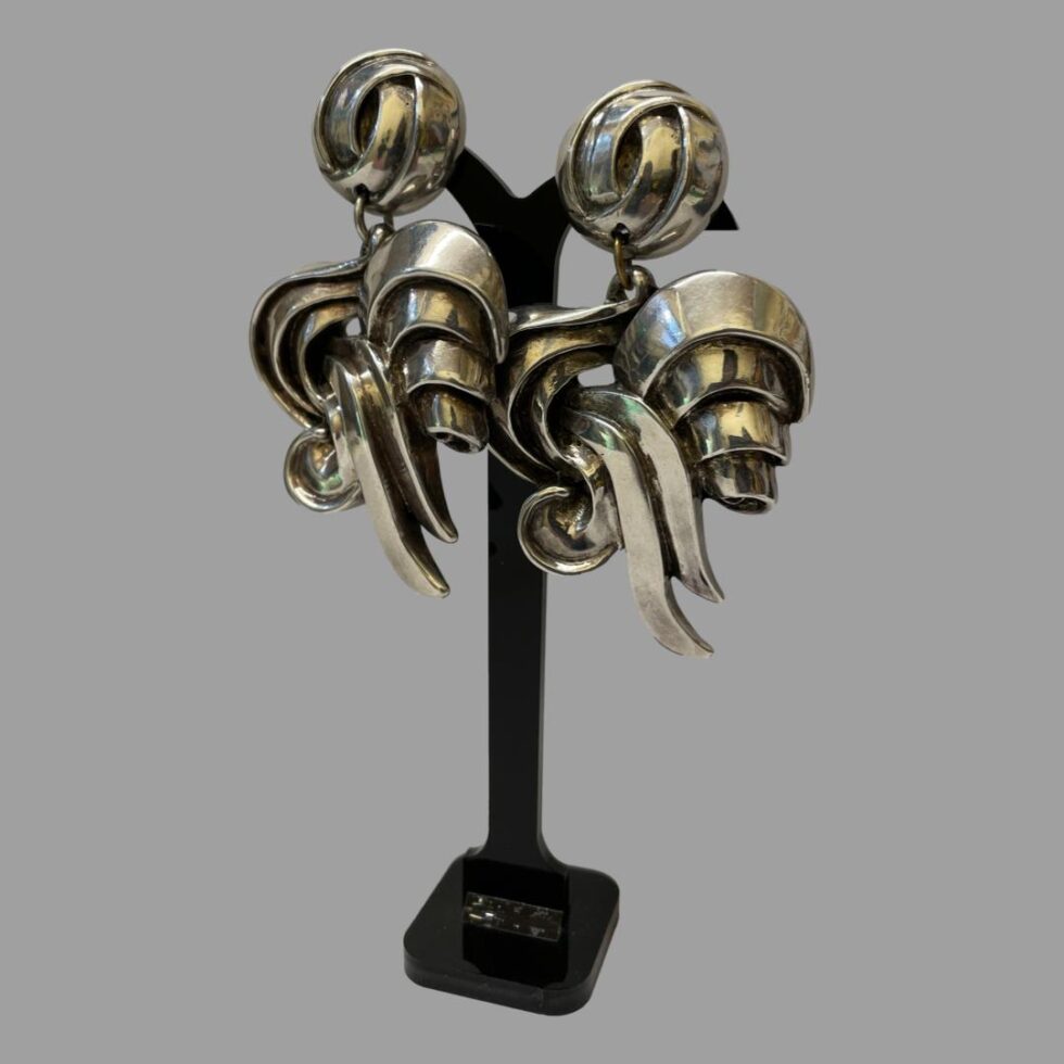 Photo of earrings displayed hanging from an earring display stand. These large statement earrings are quite substantial as can be seen with the stand being almost obscured save for a small area at top and stand at bottom.