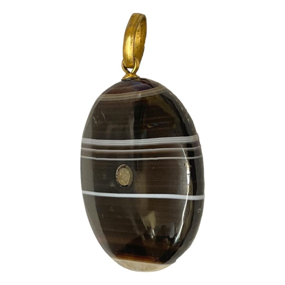 Photo of banded agate Stanhope pendant this time seen from a slight side angle with the Stanhope viewing area facing to the bottom left corner.