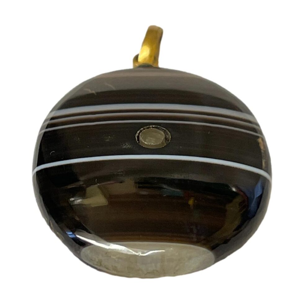 Photo of the banded agate Stanhope laid flat with the base in the foreground. The bottom of the Stanhope has a lovely little light grey patch as if nature designed!