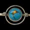 Main photo of Bernard Instone silver brooch seen from the front and focusing on the blue and gold enamel ball area at centre of the bar. The blue enamel circle to the centre has a fine silver ring around it. The blue enamel is of a dark turquoise colour with fissure like lines and a small crack opening which are all gold filled and looking like gold molten lava. There is a second 'satellite' ring of silver around the central blue circle adding another dimension.