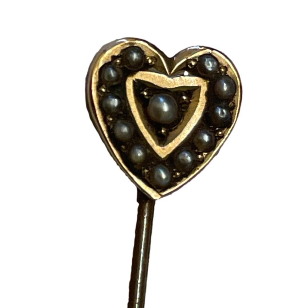 Photo of the heart area of the pin showing the double heart design with seed pearls between the 2 frames and one in the centre. The pearls are a light grey colour but look black here!