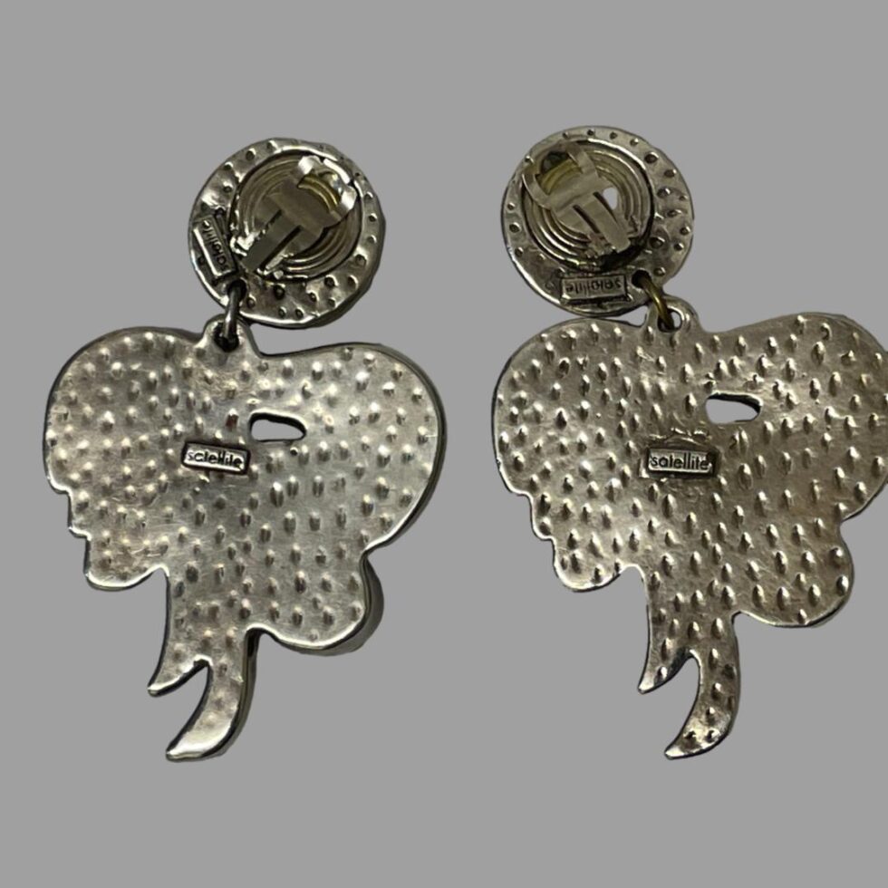 Photo of the backs of both 80s designer clip-on earrings. Makers stamp is visible to the back of both.