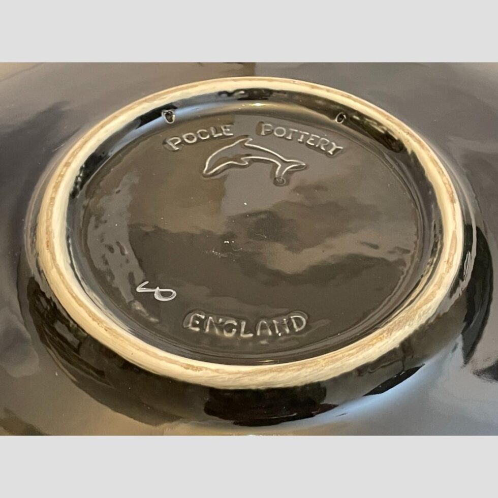 Close up photo of the embossed Poole Pottery mark and dolphin logo at the centre of the base.