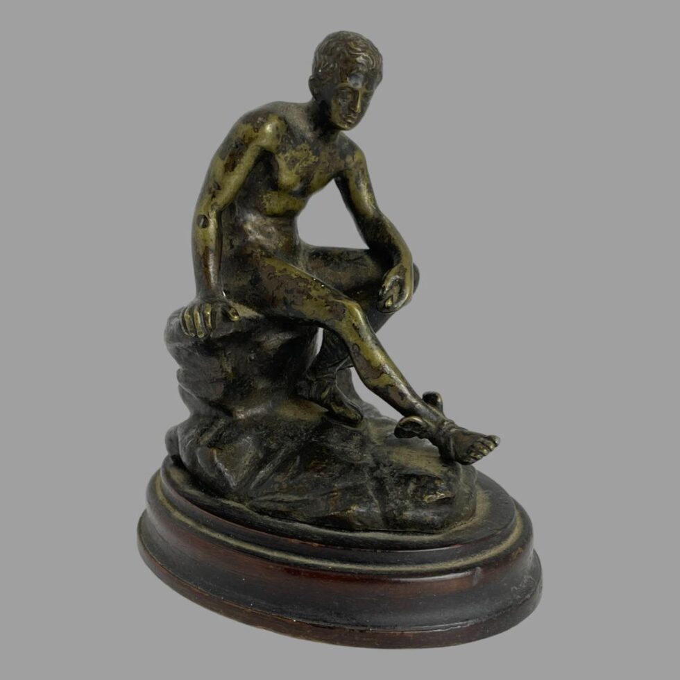 Main photo of Grand Tour Hermes bronze displayed with the forward placed right leg pointing to the bottom right corner. His left arm rests on his leg leg and he looks in deep thought. The bronze has an interesting patina with a slightly green tinge to the bronze which adds character to the piece. A fabulous miniature bronze for the discerning collector.