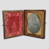Main photo of c1850 Victorian daguerreotype displayed upright and open revealing the plush dark pink velvet to the left and the striking image of a handsome Victorian lady to the right.