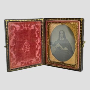 Main photo of c1850 Victorian daguerreotype displayed upright and open revealing the plush dark pink velvet to the left and the striking image of a handsome Victorian lady to the right.