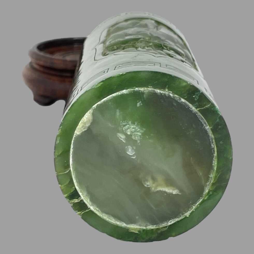 Photo of the jade brush pot displayed laid flat with the base on display. The stand is visible to the back left.