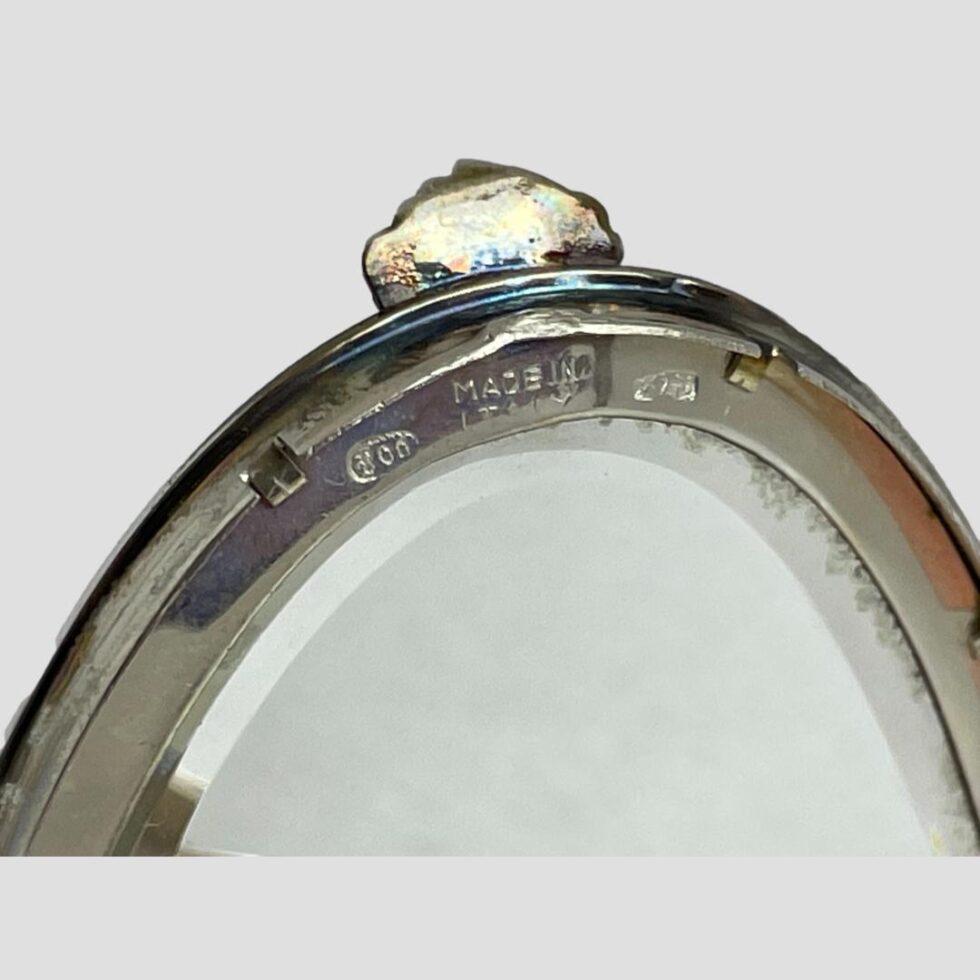 Close up photo of the 800 hallmark to the top of the inside mirror just below the scallop opener.