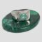 Main photo of modern silver emerald ring displayed on a small oval polished malachite with the ring front forward facing. This is a nice chunky ring with gemstone setting - quite unusual combination. The green of the emerald is a paler shade which works nicely with the silver.