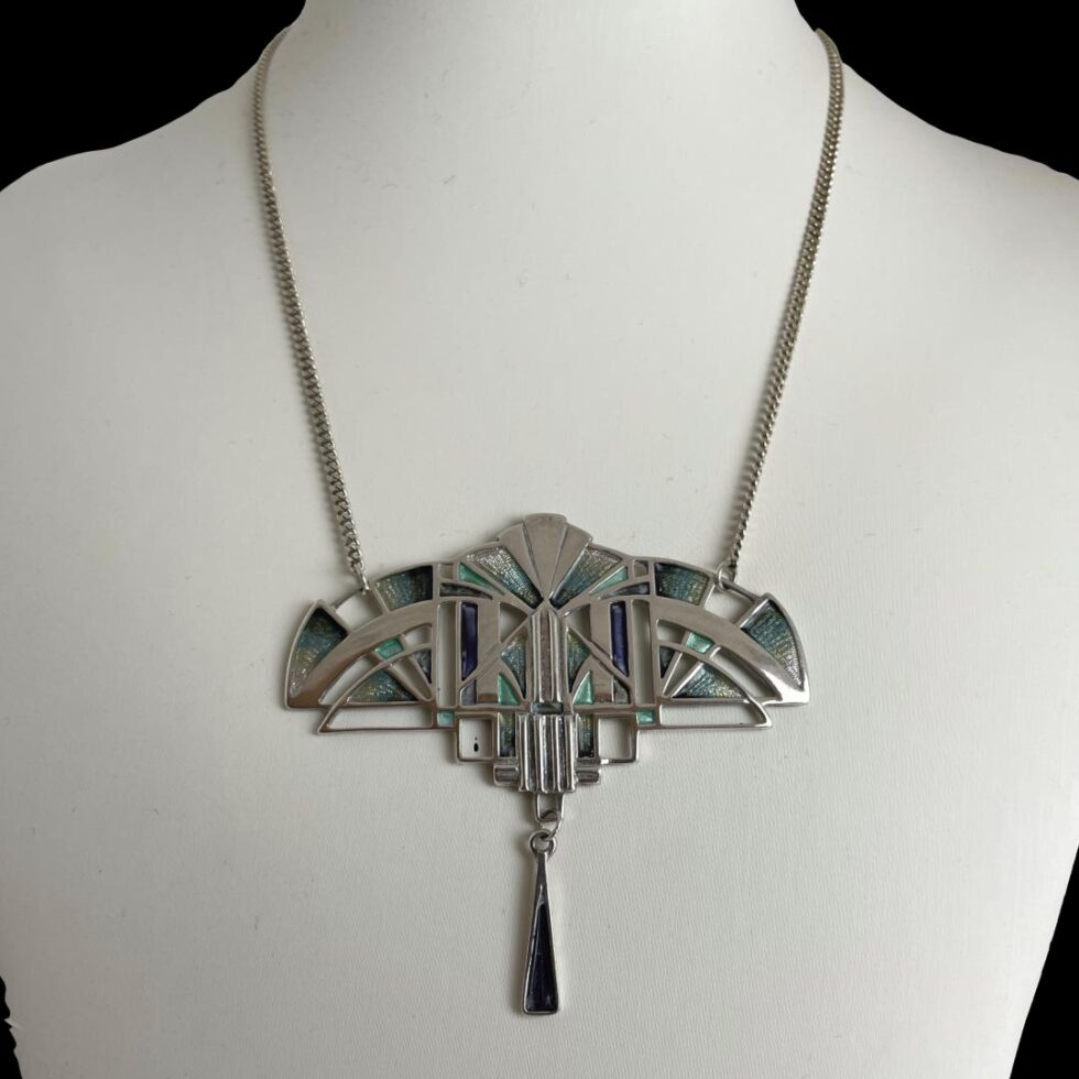 Photo of necklace displayed on a necklace display stand .