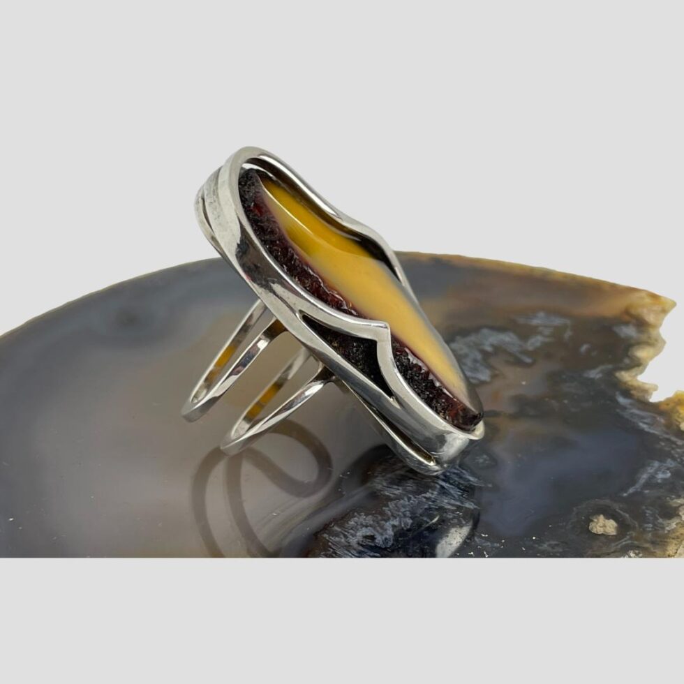 Photo of large Baltic amber ring this time facing right showing the silver work to the sides of the amber with the double band visible.