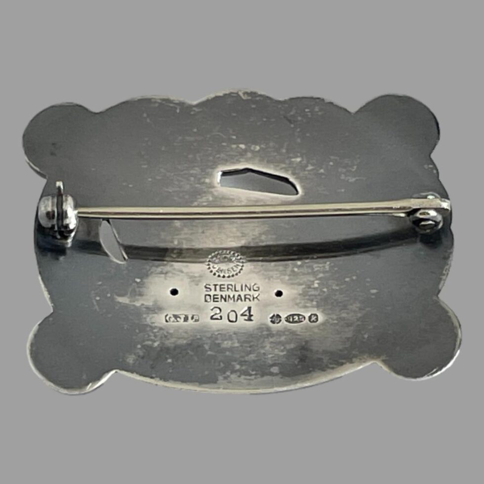 Photo of the back of Georg Jensen brooch showing the hallmark. The pin is shown closed.
