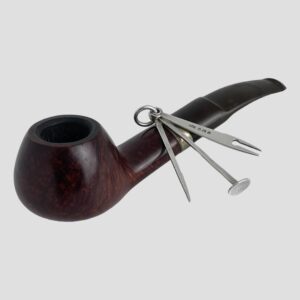 Main photo of Edwardian pipe cleaning set displayed leaning against an old smokers pipe. The pick is to the left, tamper in centre and the reamer with full hallmark on display is to the right.