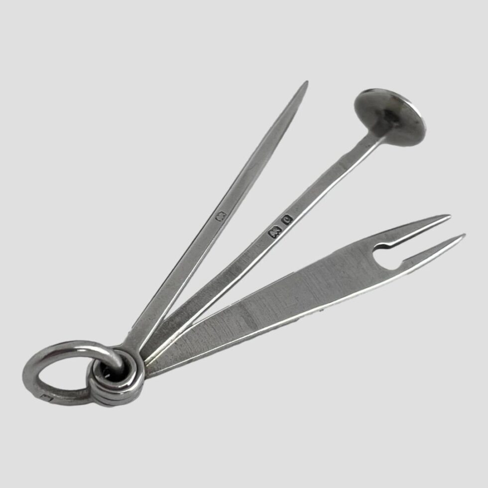 Photo of the tools laid out in fan form this time with the ring clasp in the bottom left corner. The hallmark on the ring clasp, pick and tamper is visible.