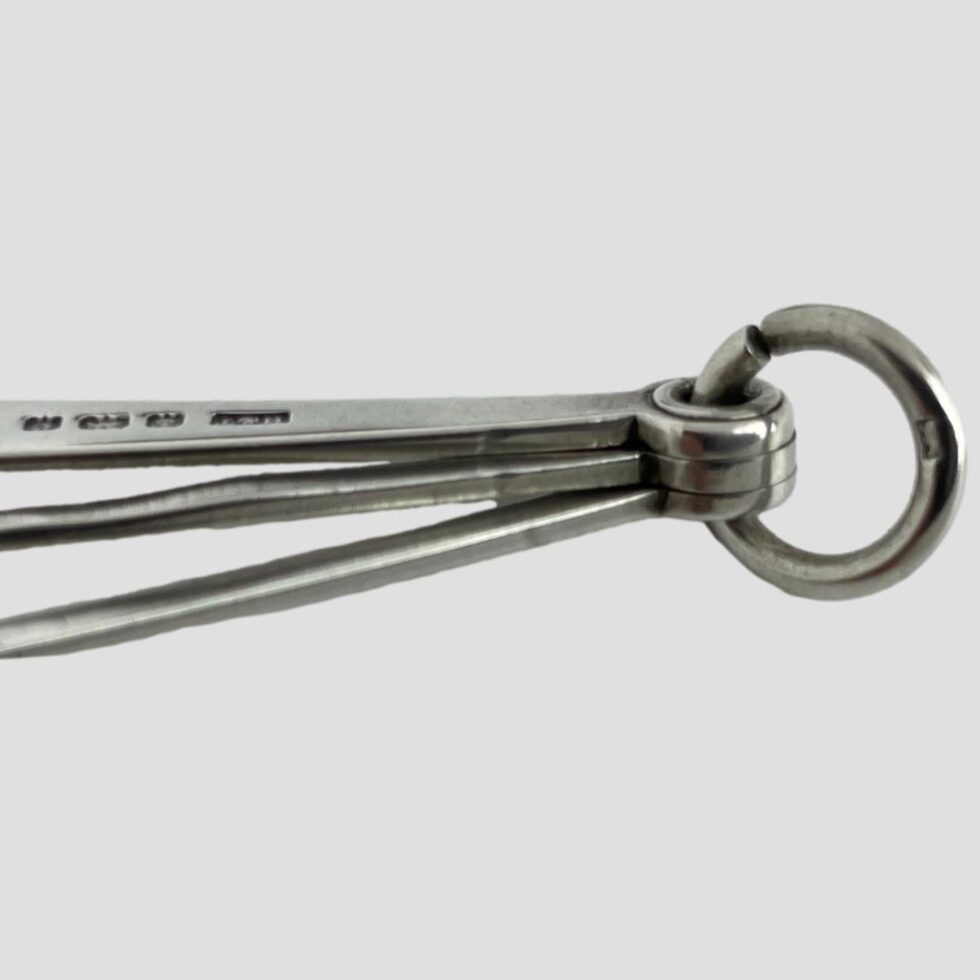 A close up photo of the full hallmark on the reamer and the worn 925 hallmark on the ring clasp holding all 3 tools neatly together.