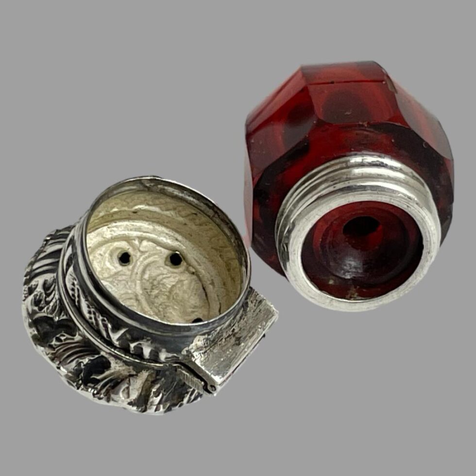 Photo of acorn shaped smelling salts bottle with the hole screw top removed .