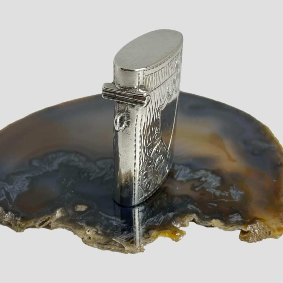 Photo of Edward VII vesta still on top of a slice of agate with the shield front now facing towards the bottom right corner.